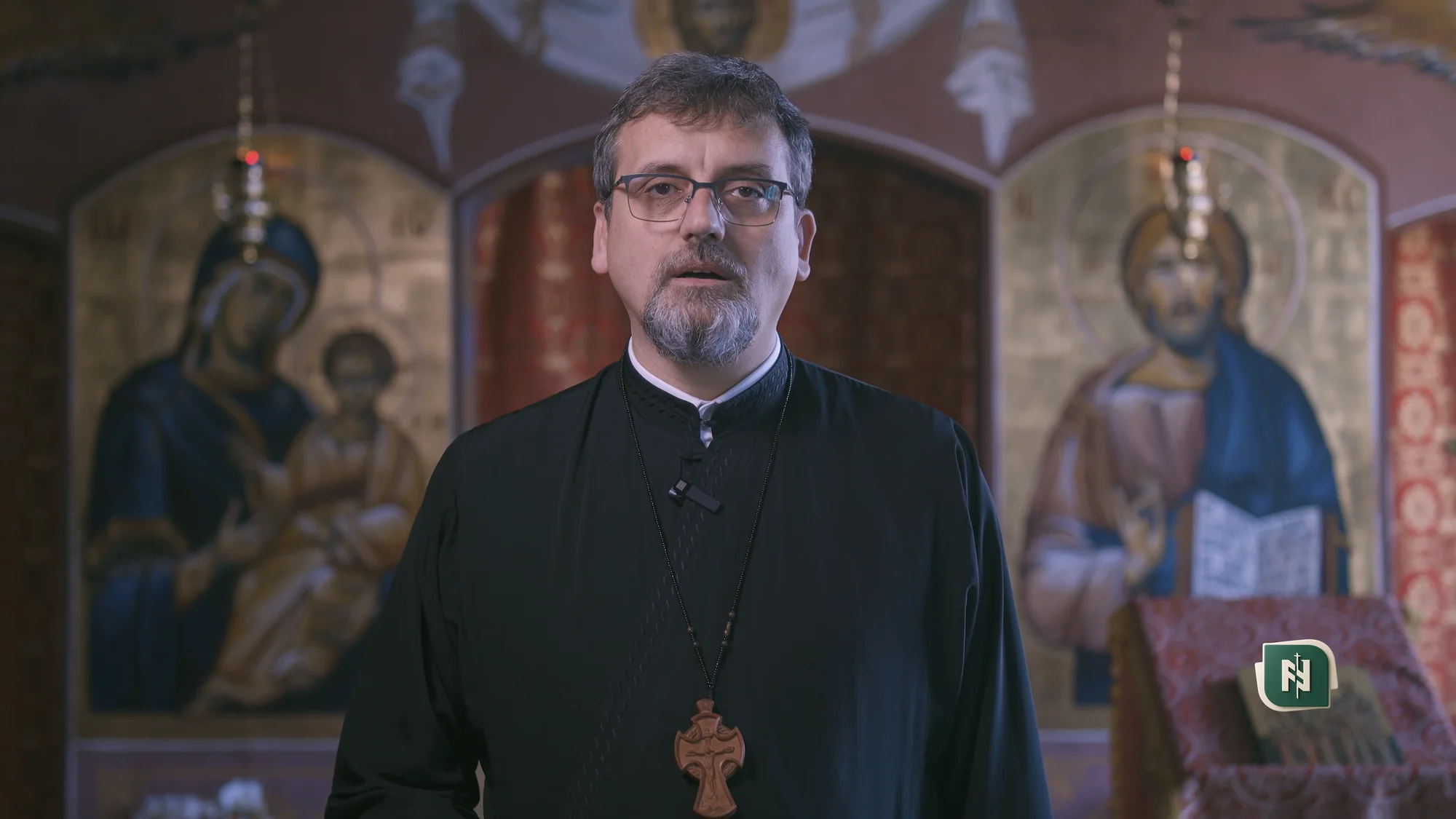 Cadru de interviu filmat într-un birou, văzut pe ecranul unui iMac, în format ultrawide cu benzi negre late sus și jos