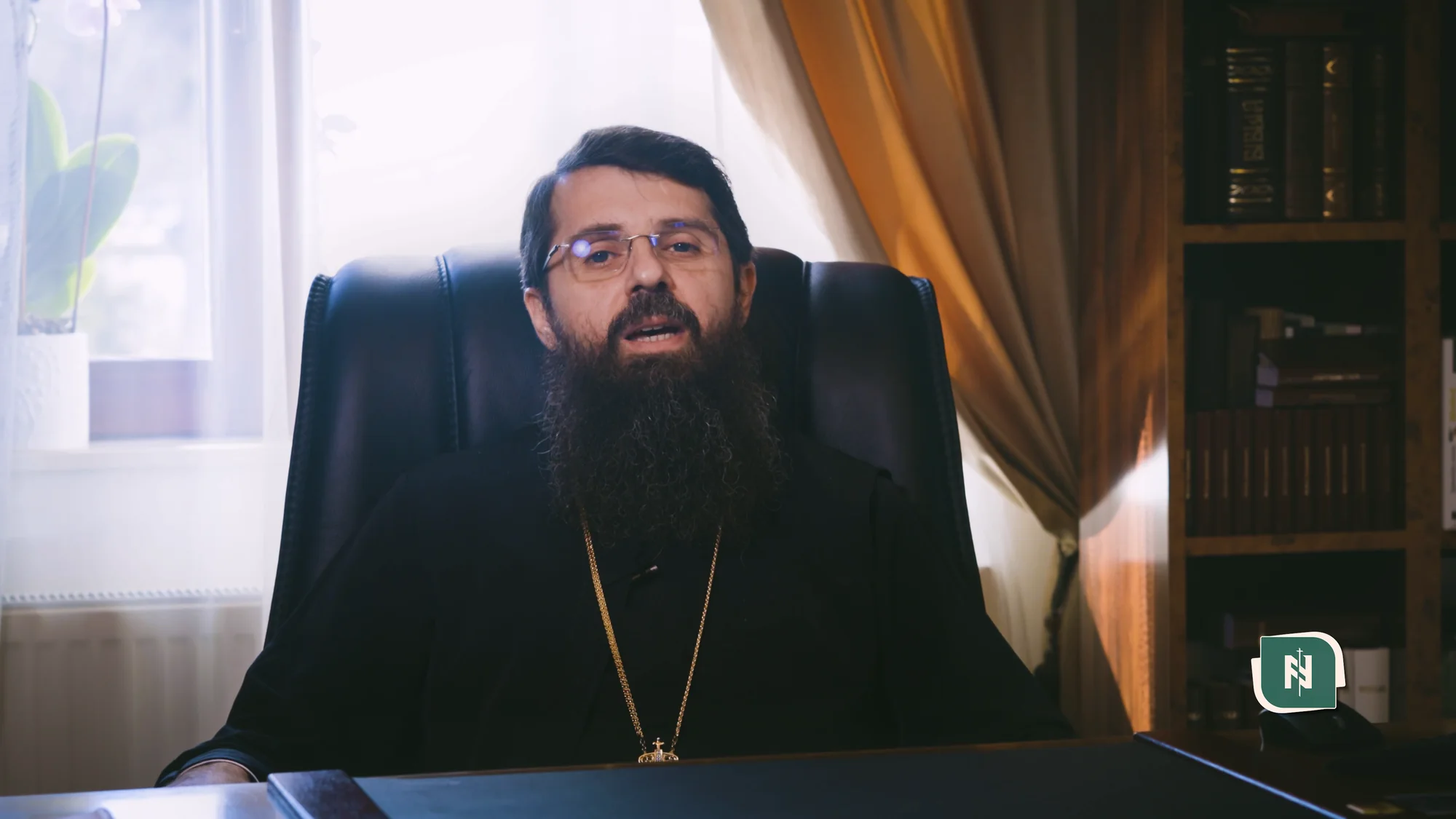 Directorul liceului, filmat în fața icoanelor.